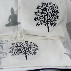 May include: Three white fabric panels with black printed designs. The top panel features a stylized tree, the middle panel features a seated Buddha, and the bottom panel features another stylized tree.