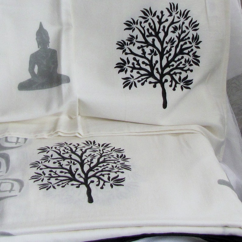 May include: Three white fabric panels with black printed designs. The top panel features a stylized tree, the middle panel features a seated Buddha, and the bottom panel features another stylized tree.