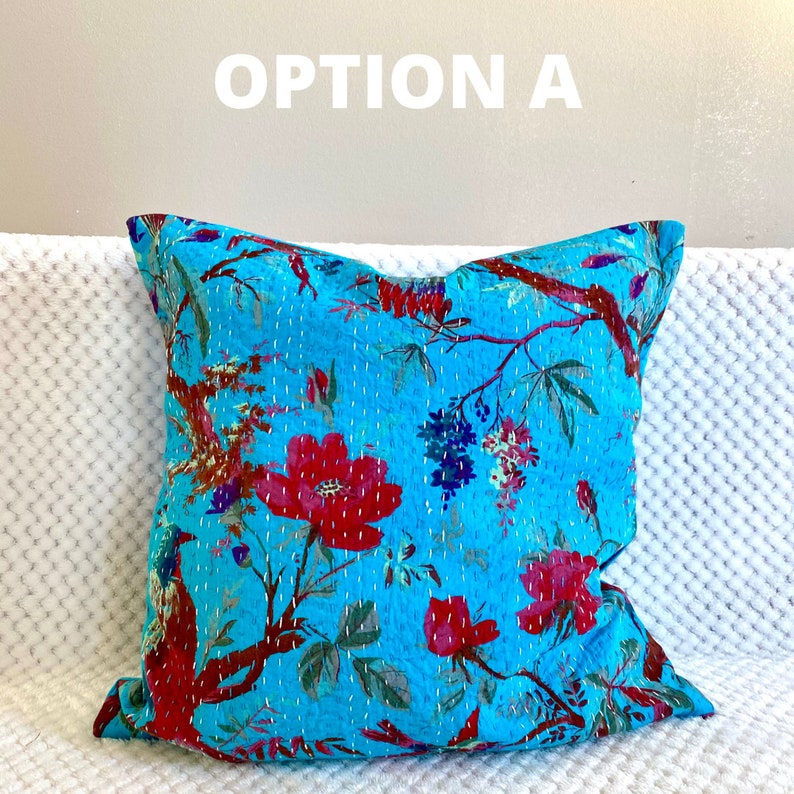 May include: A turquoise blue throw pillow with a floral pattern featuring red, pink, and white flowers, green leaves, and small birds. The pillow has a quilted design and is made of cotton.