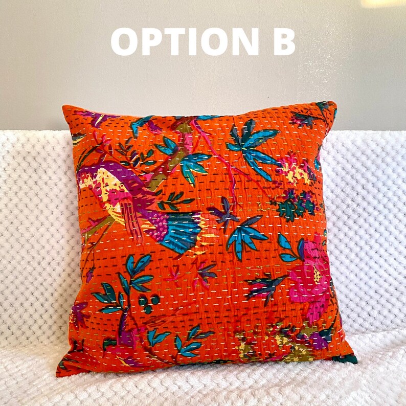 May include: Orange throw pillow with a floral and bird pattern. The pillow is quilted and has a white background with orange, blue, pink, and green accents.
