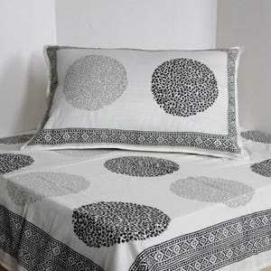 May include: White cotton bedding with a black and gray floral pattern. The bedding features a pillowcase with a black and gray floral design.