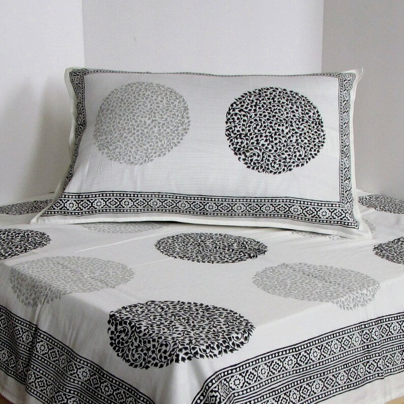 May include: White cotton bedding with a black and gray floral pattern. The bedding features a pillowcase with a black and gray floral design.