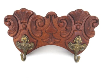 Antique coat rack with two cherub hooks. #968G63K6