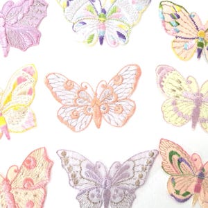 Puede incluir: Parches bordados con forma de mariposas en varios colores pastel, como rosa, amarillo y lavanda. Cada mariposa presenta costuras detalladas y un diseño delicado, ideal para manualidades o para adornar prendas.