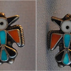 May include: Two matching silver-toned bird-shaped earrings. Each earring features a turquoise, orange, black, and white inlay design. The bird's head and tail are black, with turquoise accents. The wings are orange. The center has a turquoise inlay.
