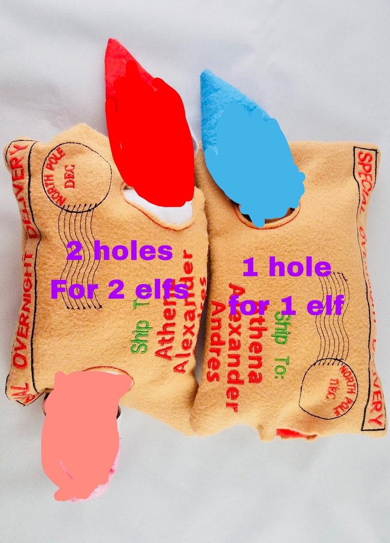 May include: Two tan felt elf pouches with red and blue elf hats. The pouches have text that reads "Overnight Delivery" and "North Pole Dec." One pouch has "2 holes for 2 elves" and the other has "1 hole for 1 elf."