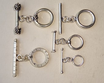 May include: Six silver toggle clasps with different ring styles. The clasps are made of metal and have a polished finish.