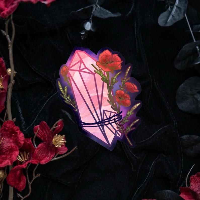 May include: A die-cut sticker featuring a pink, faceted crystal point wrapped in dark blue cord, adorned with vibrant red poppy flowers and green stems, set against a dark purple and black gradient background with sharp, defined edges.