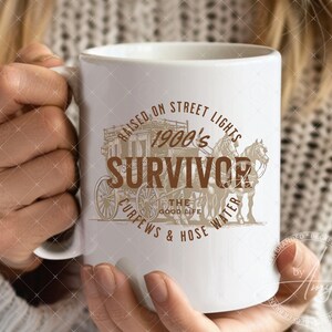 May include: White ceramic mug with a brown graphic design featuring a horse-drawn carriage and the text "Raised on Street Lights 1900's Survivor Curfews & Hose Water The Good Life".