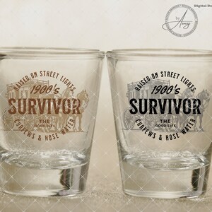 May include: Two clear glass shot glasses with a brown graphic design. The design features a horse-drawn carriage with the text "Raised on Street Lights 1900's Survivor The Good Life Curfews & Hose Water".
