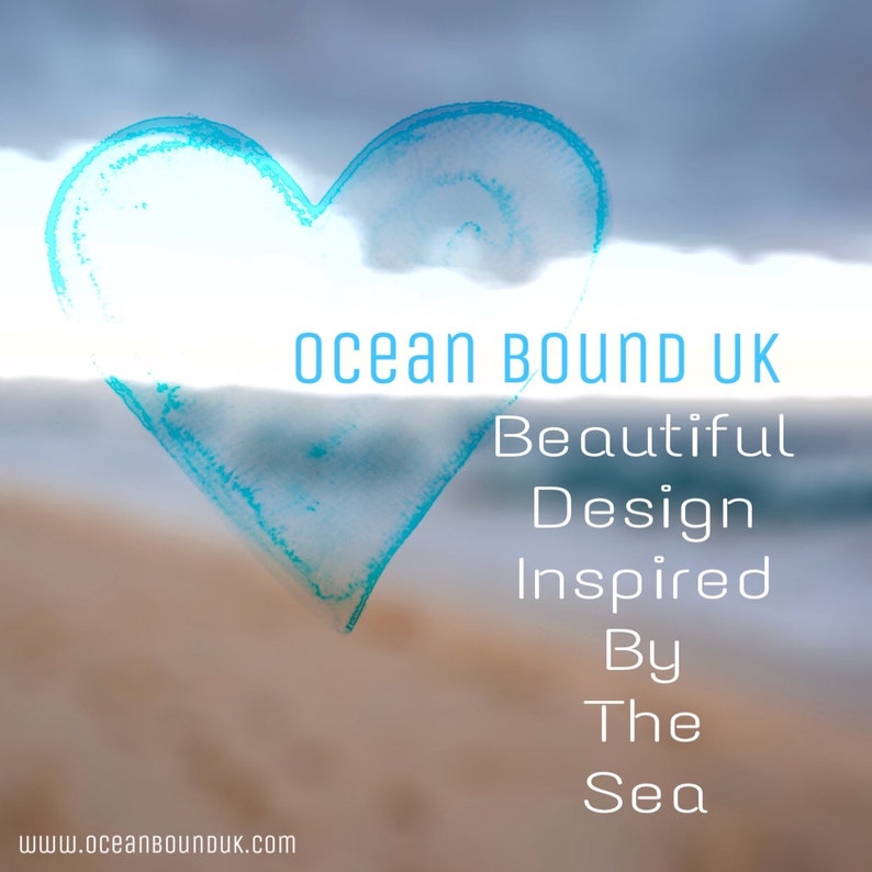May include: A blue watercolor heart shape against a blurred background of a beach and ocean. The text "Ocean Bound UK" is above the heart, and the text "Beautiful Design Inspired By The Sea" is below the heart.