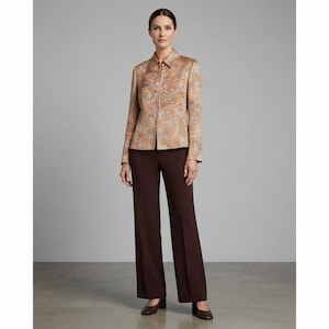 Puede incluir: Una chaqueta de manga larga con un estampado animal en tonos beige y marrón, cuello y cierre de cremallera frontal, combinada con un pantalón de color marrón oscuro liso de corte recto con una raya planchada en la parte delantera.