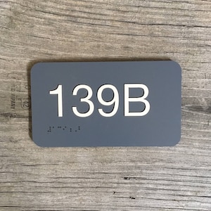 Interior room number sign, raised plastic lettering, Braille
