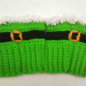 Puede incluir: Calentadores de piernas de crochet verde con un cinturón negro y una hebilla dorada. La parte superior de los calentadores de piernas tiene un ribete blanco y peludo.