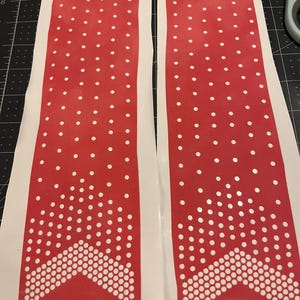 May include: Two red and white polka dot stencils with a white chevron design. The stencils are on a white background.
