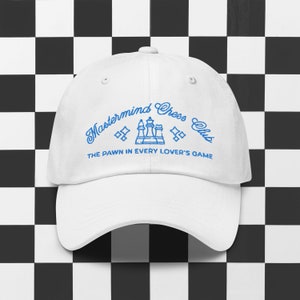 May include: White baseball cap with blue embroidery that reads "Mastermind Chess Club" and "The Pawn in Every Lover's Game".