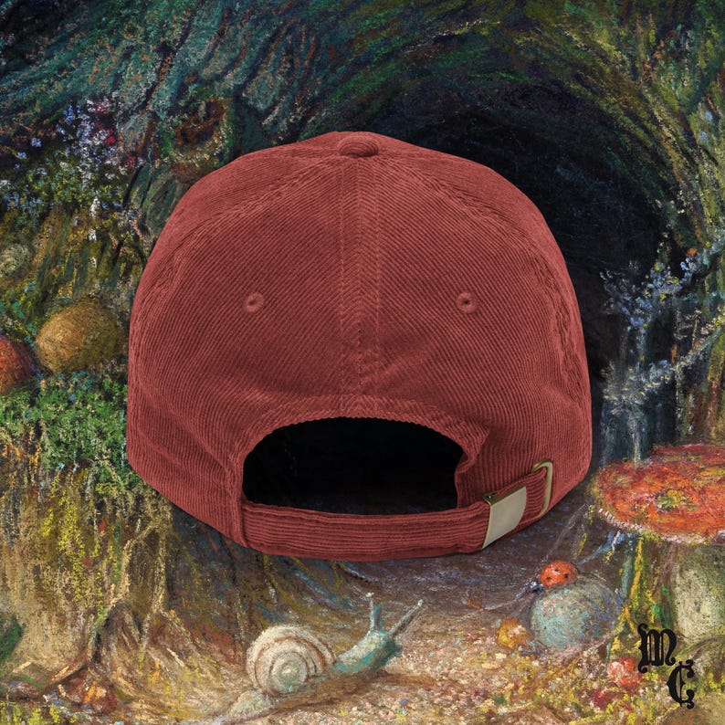 May include: A corduroy baseball cap in a deep red hue, featuring a curved brim and an adjustable metal buckle closure. The cap's design is simple and classic, suitable for casual wear. The background is a colorful painting of a forest scene.