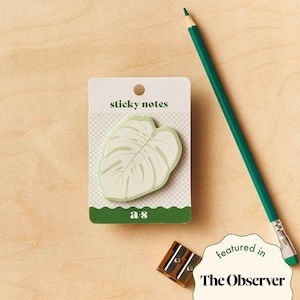 Könnte beinhalten: Ein Packung Haftnotizen mit einem grünen Monstera-Blatt-Design. Die Packung ist mit "sticky notes" und "a s" beschriftet.