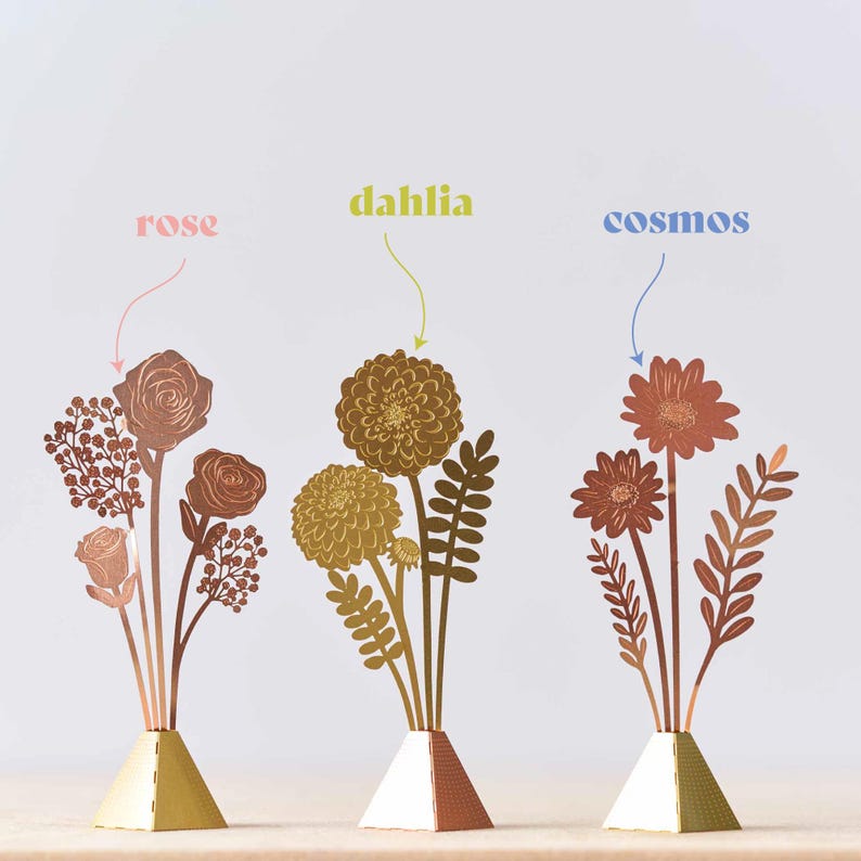 Peut inclure: Trois sculptures de fleurs en m&eacute;tal dor&eacute;, chacune avec un type de fleur diff&eacute;rent&nbsp;: rose, dahlia et cosmos. Les fleurs sont dispos&eacute;es en forme de vase sur une base en m&eacute;tal dor&eacute;.
