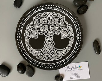 May include: A black ceramic plate with a silver Celtic tree of life design. The plate is decorated with white dots around the edge.