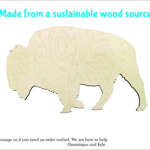 May include: A wooden bison cutout with visible wood grain. The bison is light-colored and has a black outline. Text at the top reads "Made from a sustainable wood source."