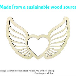 May include: A wooden cutout of a heart with wings. The heart is in the center of the image and the wings are on either side. The cutout is made from a sustainable wood source.