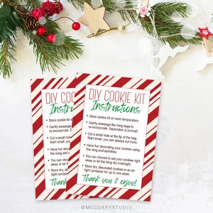 May include: Two red and white striped cards with instructions for a DIY cookie kit. The text on the cards reads "DIY Cookie Kit Instructions" and includes instructions for decorating cookies.