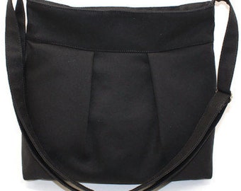 Black canvas medium-size zipper crossbody bag with adjustable strap and inside pockets