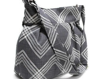 Medium-sized gray canvas crossbody bag with zip closure, adjustable strap and inside pockets