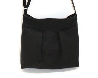 Black canvas medium-size zipper crossbody bag with adjustable strap and inside pockets