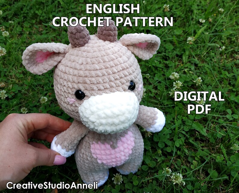 May include: Crochet pattern for a cute brown and white cow amigurumi toy. The pattern is available as a digital PDF download. The image shows the finished toy.