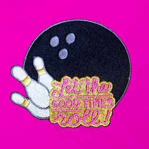 Pode incluir: Etiqueta bordada com uma bola de boliche e pinos, com o texto "Let the good times roll!" em letras douradas e rosadas.