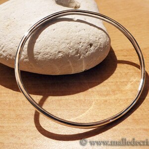 May include: A simple silver bangle bracelet, a classic and timeless piece of jewelry.