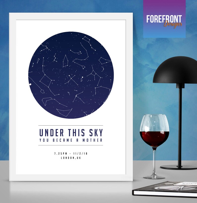 May include: A white framed print with a navy blue circle depicting a constellation of stars. The text "Under this sky you became a mother" is printed below the circle, along with the date and time "7:25PM - 11/2/18" and the location "LONDON, UK".