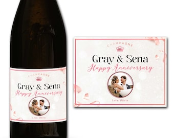 May include: Champagne bottle label with a pink and white design. The label features a photo of a couple, the text "Gray & Sena Happy Anniversary", and the words "Love, Olivia".
