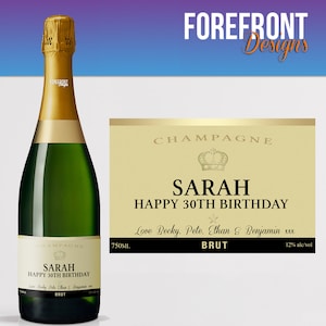 May include: A champagne bottle label with a gold background and black text. The label says "Champagne", "Sarah Happy 30th Birthday", "Love Becky, Pete, Ethan & Benjamin xxx", "Brut", "750ml", and "12% alc/vol".