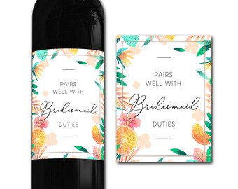 May include: A white wine bottle label with a floral design featuring pink, orange, and green flowers and leaves. The label says "Pairs well with Bridesmaid Duties".