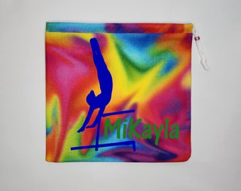 May include: A colourful tie-dye drawstring bag with a blue silhouette of a gymnast on uneven bars and the name "Mikayla" in green text.