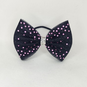 Può includere: Fiocco per capelli nero con glitter rosa e un accento di strass argentato.