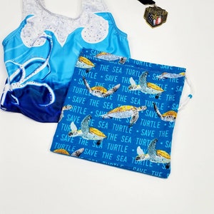 May include: A blue drawstring bag with a repeating pattern of sea turtles and the text "Save the Sea Turtle".