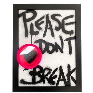 May include: A framed black and white spray paint artwork with the words "Please Don't Break" in black paint. A pink circle with a black heart inside is attached to the artwork.