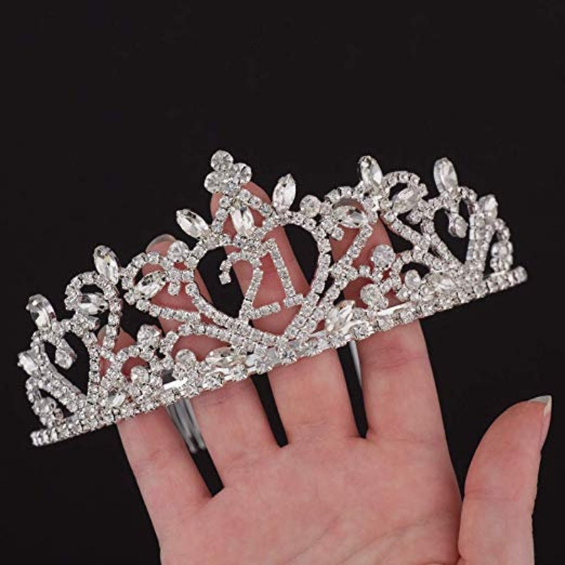 May include: Silver tiara with rhinestones and the number 21 in the center.