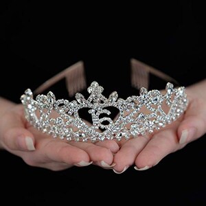 K&ouml;nnte beinhalten: Eine silberne Tiara mit Strasssteinen und der Zahl 16 in der Mitte.