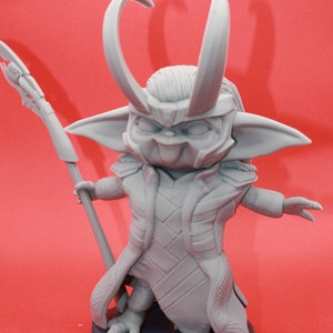 May include: A grey 3D printed figurine of a character with horns, a long robe, and a staff. The character is standing on a round base.