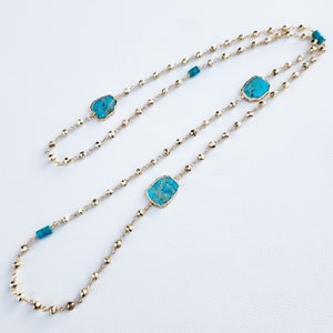 May include: A gold chain necklace with three turquoise stones. The stones are irregular in shape and have a mottled pattern.