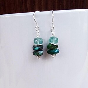 May include: Silver dangle earrings with a graduated stack of blue-green gemstone beads.