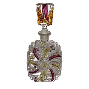 May include: A clear glass perfume bottle with a textured design and a colourful stopper. The stopper is made of glass and has a swirl pattern in shades of yellow and purple.