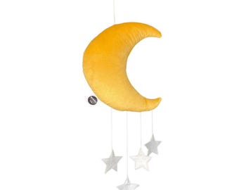 Könnte beinhalten: Ein Mobile mit einem gelben Halbmond und vier silbernen Sternen. Der Mond besteht aus einem weichen, strukturierten Stoff, die Sterne aus glänzendem Metall. Das Mobile ist für ein Kinderzimmer konzipiert.