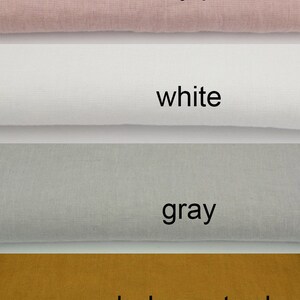 May include: Image of fabric swatches in four colours: dusty pink, white, grey, and dark mustard. Each colour is labelled with its name in black text. The fabric appears to be linen or a similar natural material.