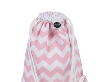 Könnte beinhalten: Rucksack mit Kordelzug und rosa-weißem Chevron-Muster. Die Tasche hat ein sich wiederholendes Zickzack-Design in Hellrosa und Weiß. Weiße Kordelzüge dienen zum Verschließen der Tasche. Der Markenname "NUKKO design" ist auf einem kleinen runden Etikett aufgedruckt.